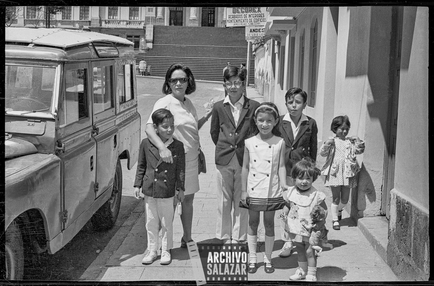 Vida familiar del barrio, una madre y sus seis hijos vecinos de la calle Arenas, al fondo el Colegio Mejía. 
Roberto Salazar, 1972 ©ArchivoSalazar